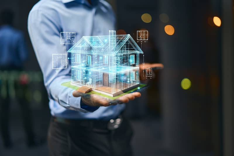 Person hält digitale 3D-Hologramm-Darstellung eines Hauses mit transparenten Bauplänen